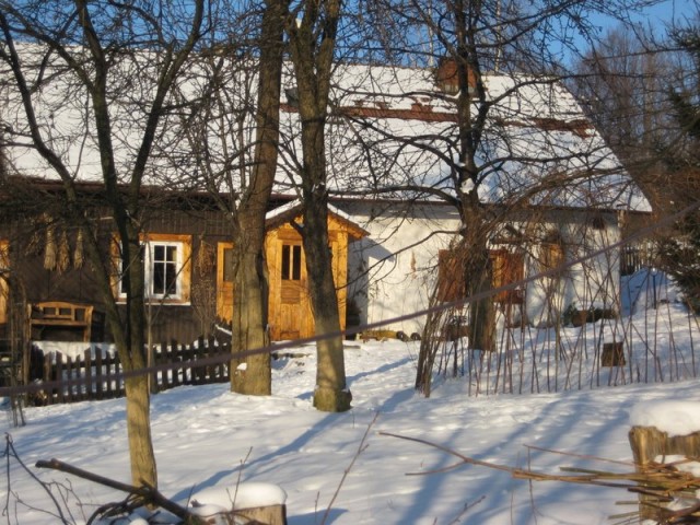 Tradycyjny drewniano-kamienny wiejski dom zimą
